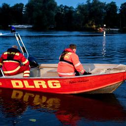 Helfer der DLRG sind mit einem Boot auf einem See unterwegs.