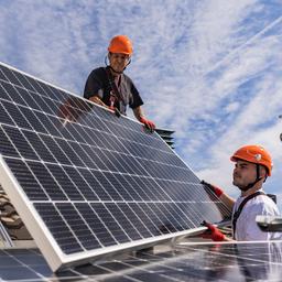 Montage von Solarpaneelen auf einem Hausdach.