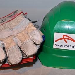 Arbeitshandschuhe und ein Bauhelm liegen im Werk der ArcelorMittal Eisenhüttenstadt GmbH.
