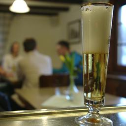 Ein Glas mit Bier steht am Tresen in einer Gaststätte.