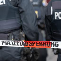 Polizisten hinter einem Absperrband (Mottobild)