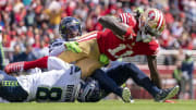 September 18, 2022; Santa Clara, California, USA; San Francisco 49ers wide receiver Brandon Aiyuk (11) is tackled by Seattle Seahawks cornerback Coby Bryant (8) and safety Quandre Diggs (6) during the first quarter at Levi's Stadium.