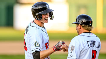 Lugnuts' Will Simpson, left, celebrates his two-run double with manager Craig Conklin during the fifth inning in the game against the Loons on Tuesday, April 9, 2024, at Jackson Field in Lansing.