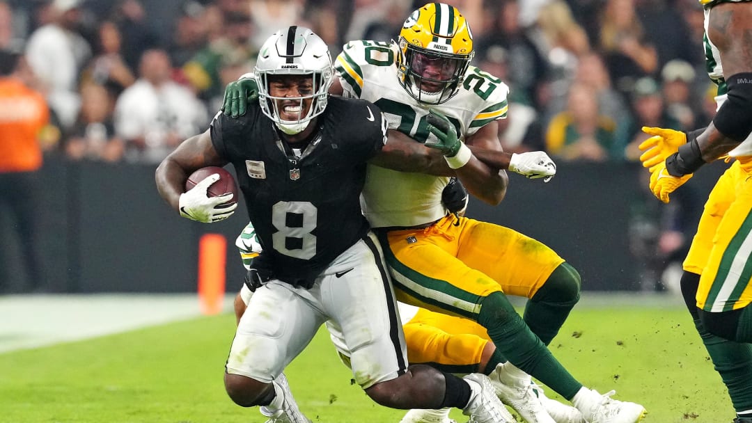 Oct 9, 2023; Paradise, Nevada, USA; Green Bay Packers safety Rudy Ford (20) tackles Las Vegas Raiders running back Josh Jacobs (8) during the third quarter at Allegiant Stadium. Mandatory Credit: Stephen R. Sylvanie-USA TODAY Sports