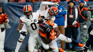 Nov 26, 2023; Denver, Colorado, USA; Denver Broncos running back Samaje Perine (25) is tackled by Cleveland Browns cornerback Greg Newsome II (0) and linebacker Tony Fields II (42) in the third quarter at Empower Field at Mile High. Mandatory Credit: Isaiah J. Downing-USA TODAY Sports