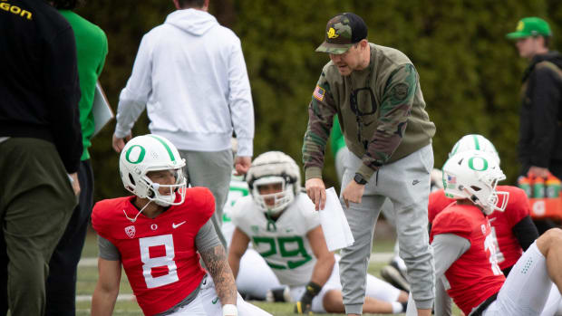 Oregon offensive coordinator Will Stein talks with quarterback Dillon Gabriel during practice with the Oregon Ducks Saturday,