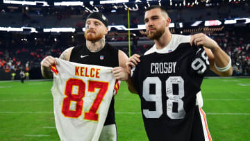 Jan 7, 2023; Paradise, Nevada, USA; Las Vegas Raiders defensive end Maxx Crosby (98) and Kansas City Chiefs tight end Travis Kelce (87) pose for photos after exchanging jerseys at Allegiant Stadium. Mandatory Credit: Gary A. Vasquez-USA TODAY Sports