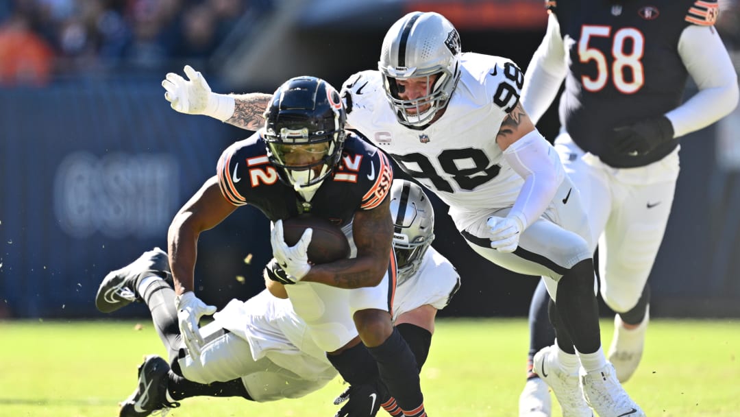 Oct 22, 2023; Chicago, Illinois, USA;  Chicago Bears wide receiver Velus Jones Jr. II (12) is brought down by Las Vegas Raiders defensive end Maxx Crosby (98) and linebacker Robert Spillane (41) after a short gain in the first quarter at Soldier Field. Mandatory Credit: Jamie Sabau-USA TODAY Sports