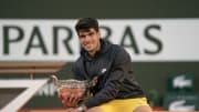 Jun 9, 2024; Paris, France; Carlos Alcaraz of Spain poses with the trophy after winning the men’s singles final against Alexander Zverev of Germany on day 15 of Roland Garros at Stade Roland Garros.