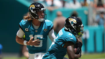 Sep 8, 2024; Miami Gardens, Florida, USA;  Jacksonville Jaguars quarterback Trevor Lawrence (16) hands off to running back Tank Bigsby (4) in the first quarter against the Miami Dolphins at Hard Rock Stadium. Mandatory Credit: Jim Rassol-Imagn Images