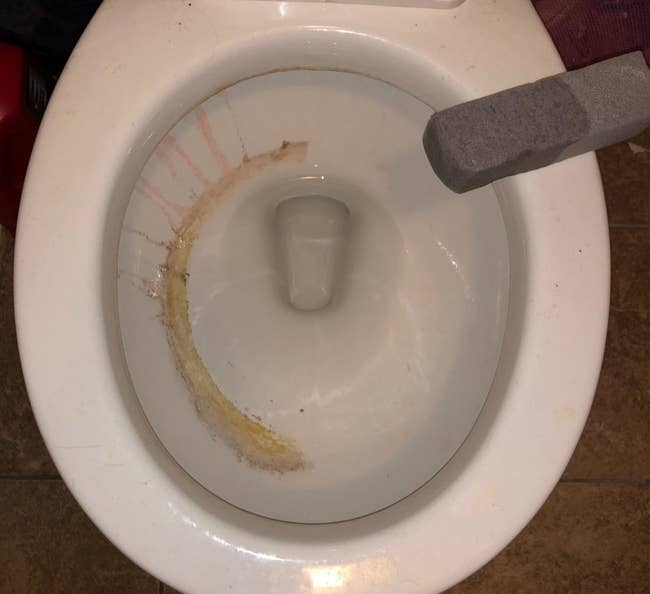 reviewer photo showing toilet half cleaned with the pumice cleaning tool 