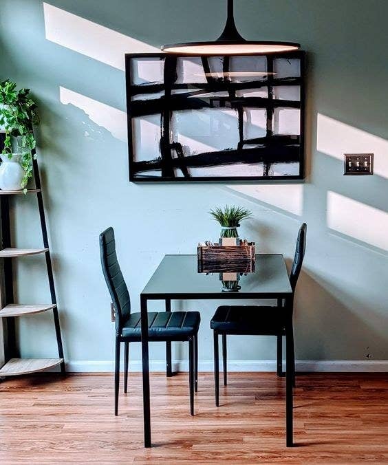 Reviewer&#x27;s picture of the black sleek dining room table and matching chairs