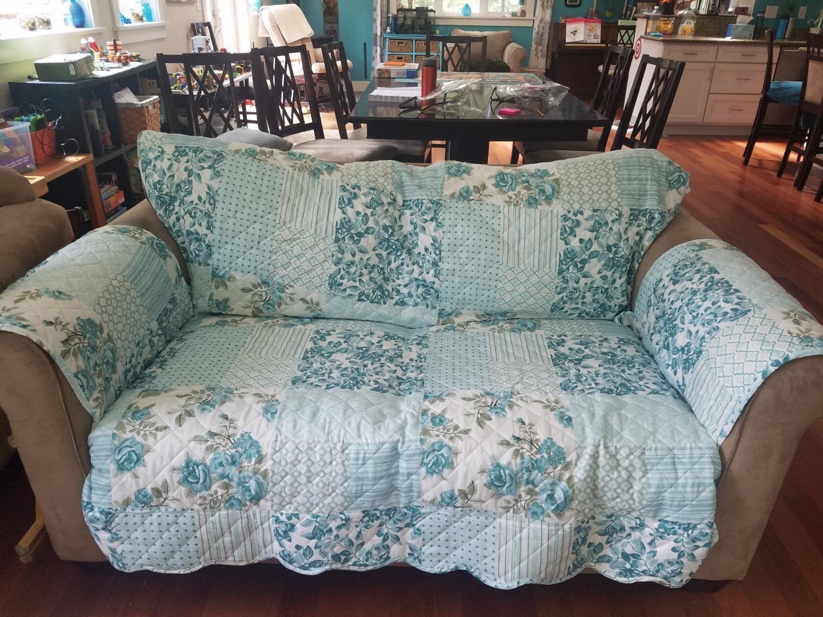 reviewer photo of the blue patchwork slipcover on a gray couch in a living room