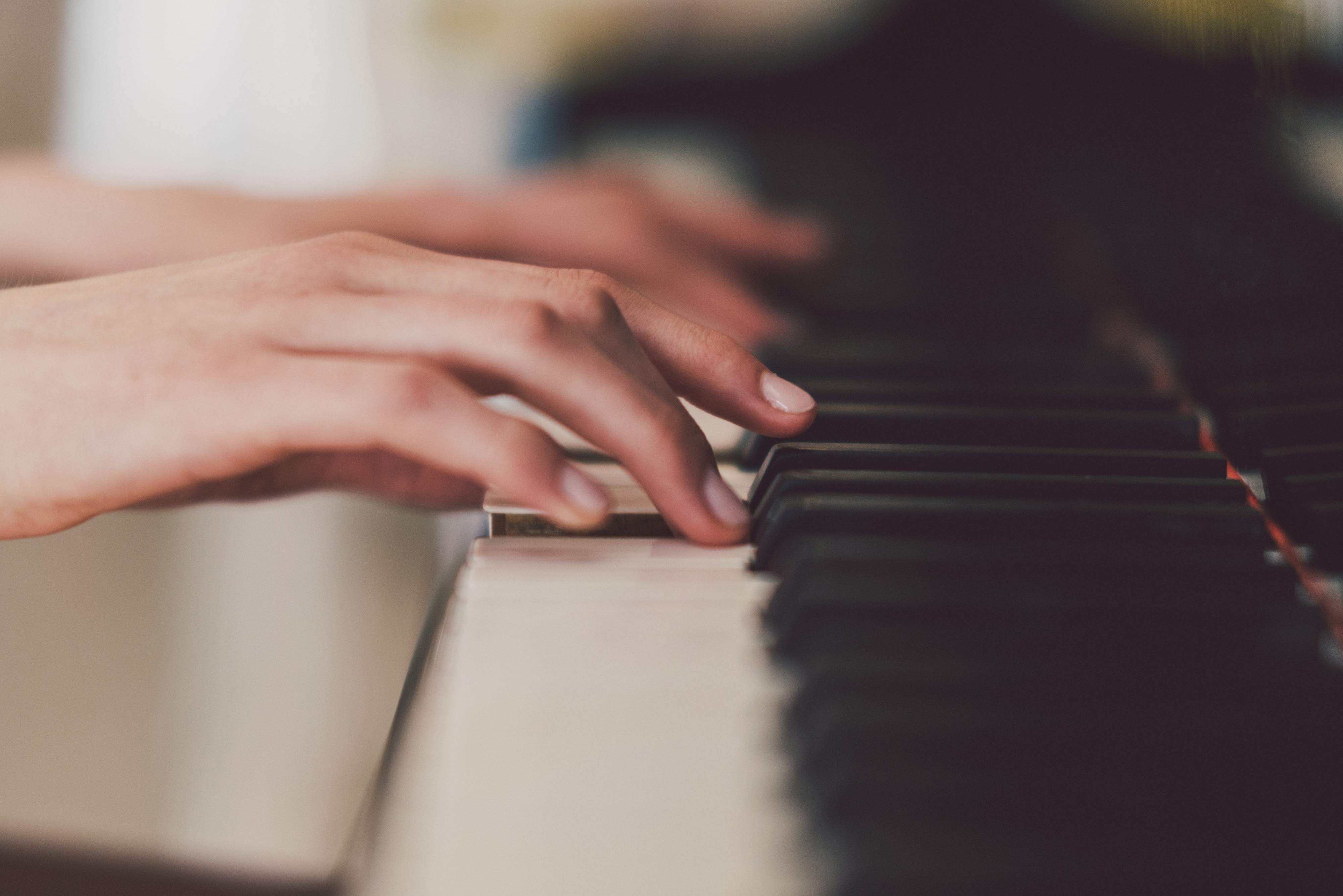 A close-up of two hands playing a piano keyboard