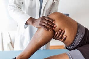 A doctor examines the knee of a patient who is lying on a medical table