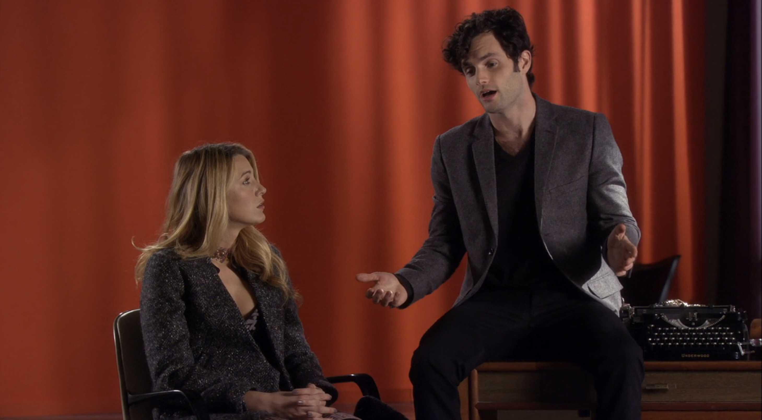 Blake Lively and Penn Badgley sitting and talking in a scene