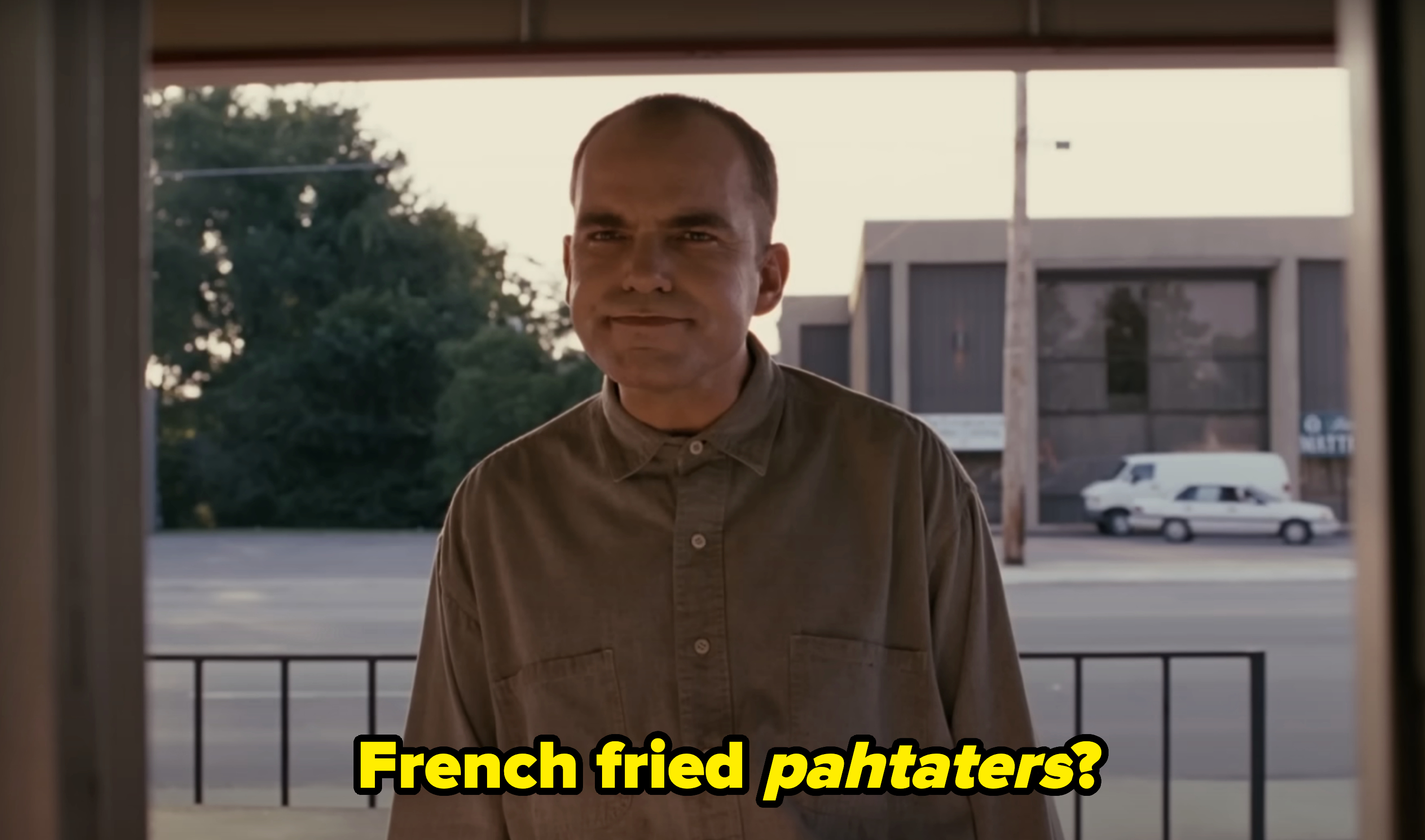 Billy Bob Thornton as Karl Childers stands outside a building, wearing a buttoned-up shirt