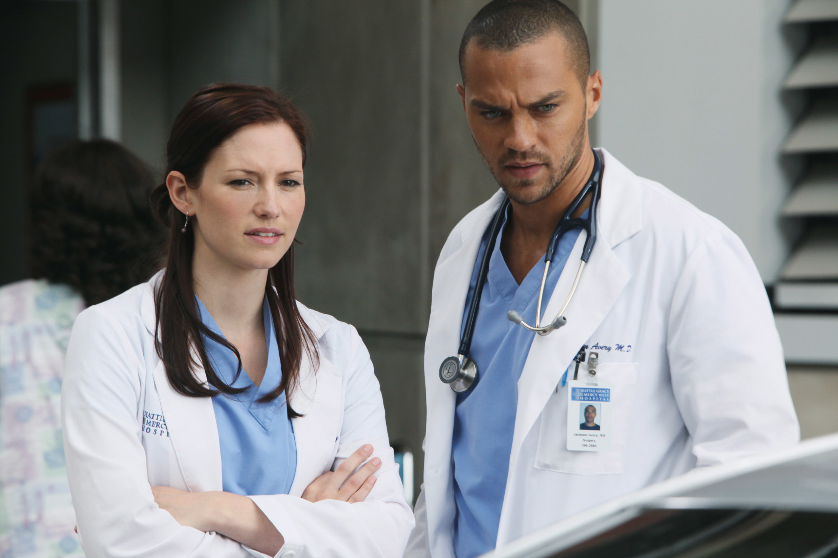 Lexie Grey and Jackson Avery, characters from Grey&#x27;s Anatomy, stand together in hospital attire with serious expressions