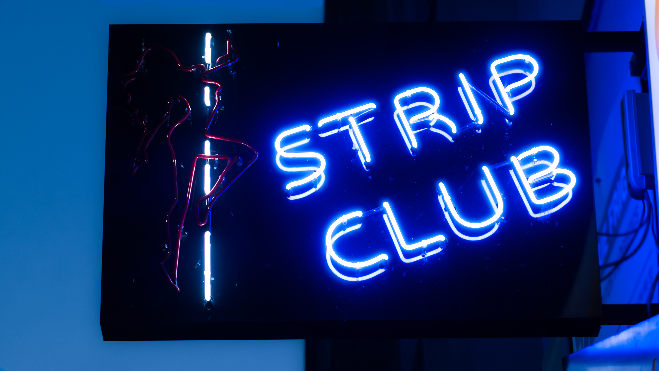 Neon &quot;Strip Club&quot; sign with a silhouette of a woman on a pole