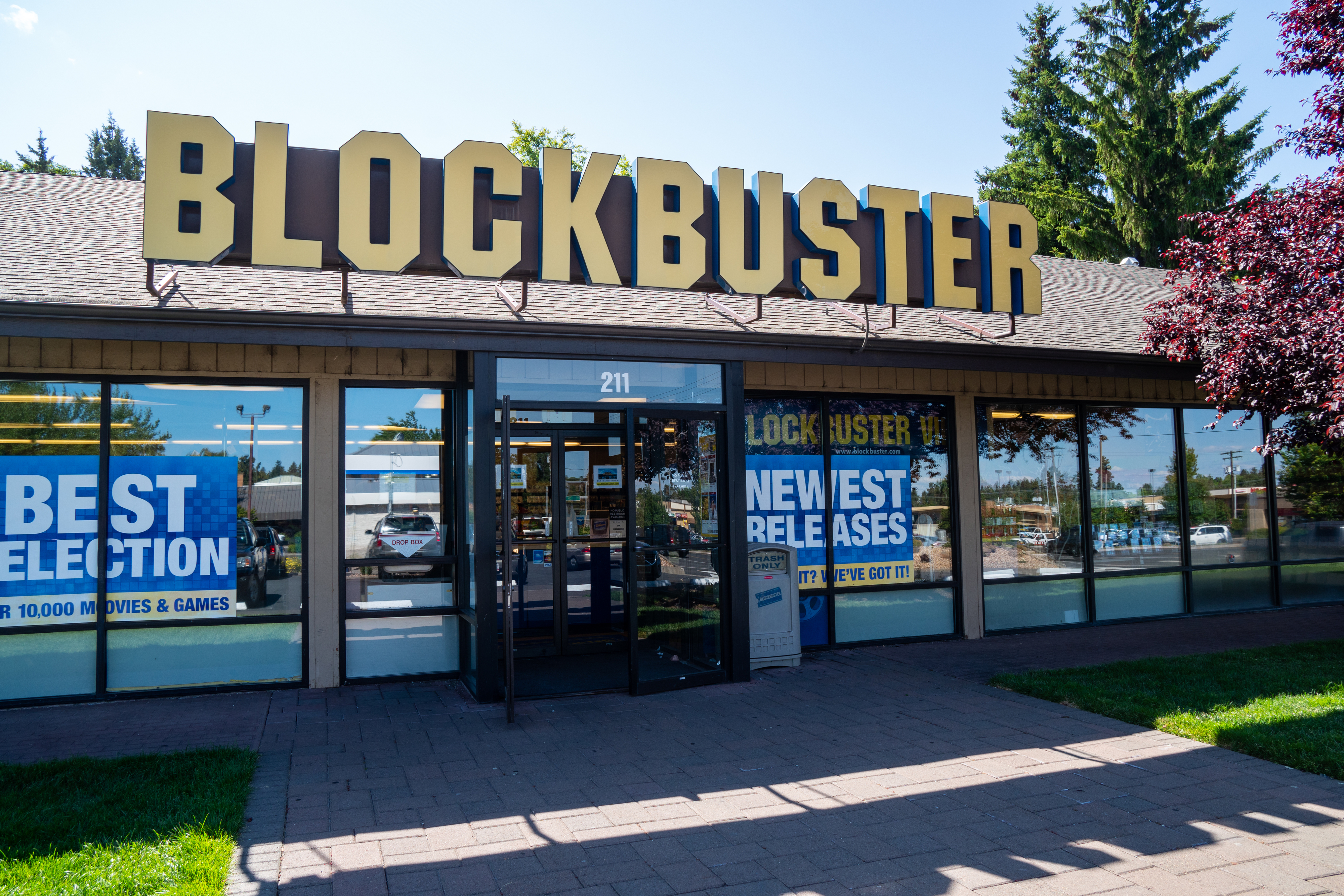 Exterior of a Blockbuster store with signs reading &quot;Best Selection&quot; and &quot;Newest Releases&quot; on its windows. The store has a large yellow Blockbuster sign above