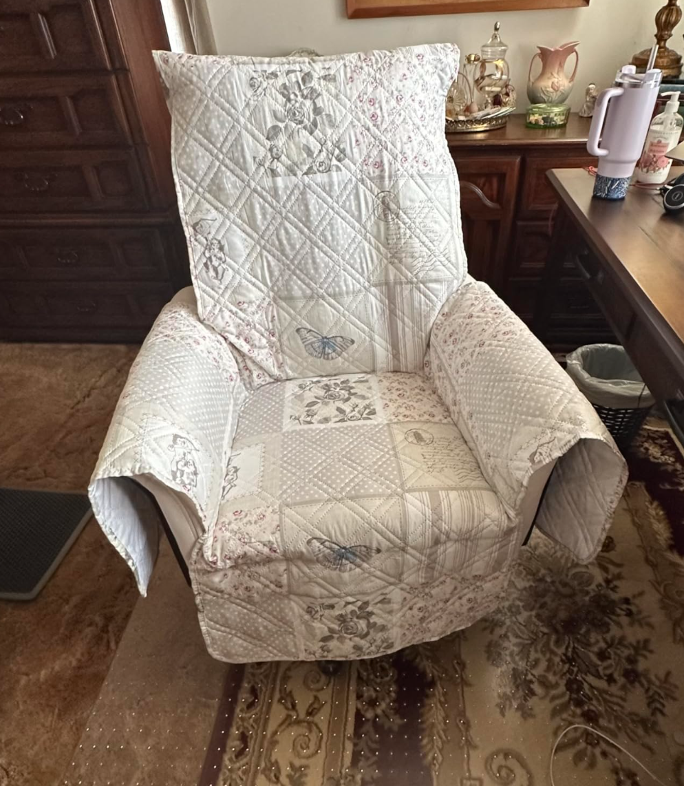 A cushioned recliner chair covered with a quilted fabric, sitting in a cozy room with wooden furniture and vintage decor for a shopping article