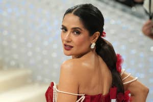 Salma Hayek on the red carpet in a corset-style dress adorned with pearls and floral accents