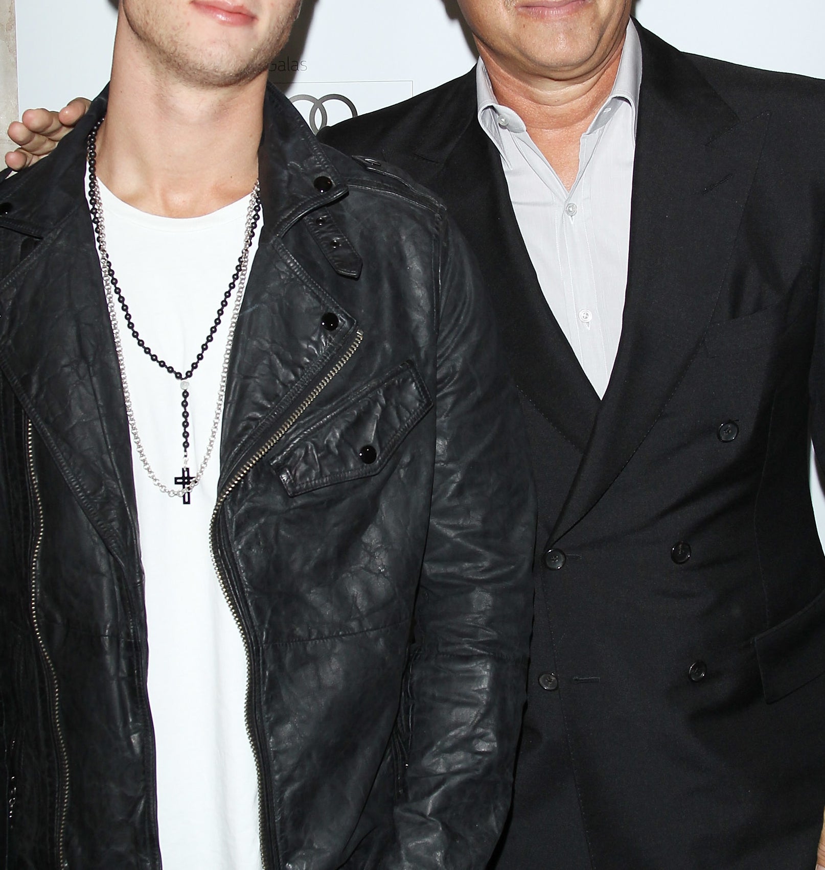 Tom Hanks and Chet Hanks pose together at a Toronto International Film Festival event. Chet is wearing a leather jacket, and Tom is in a suit
