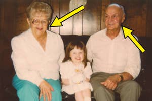 An elderly couple, each indicated by yellow arrows, sit with a young girl in the middle on a couch, all smiling