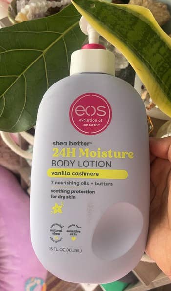 Person holding eos shea better 24H Moisture Body Lotion bottle