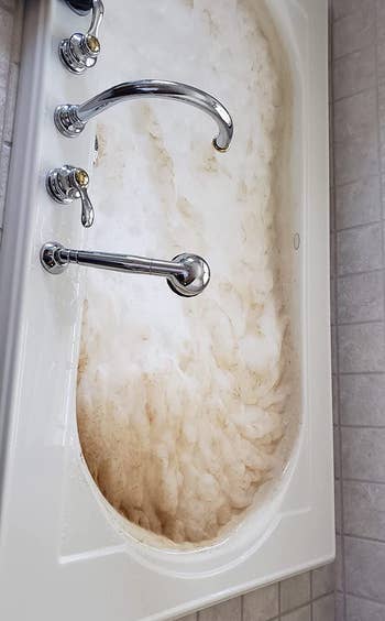 reviewer before photo showing a tub full of dirty foam while being cleaned