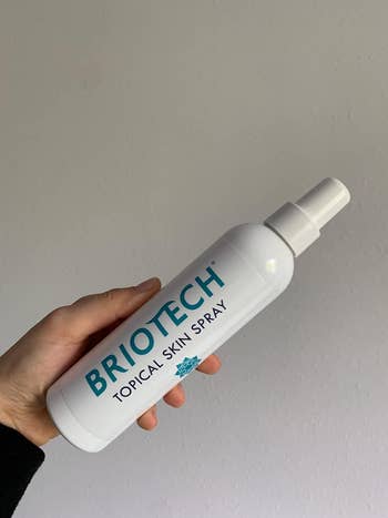 Reviewer holding their Briotech spray bottle