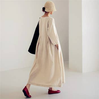 back of model wearing the cream colored dress with red flats