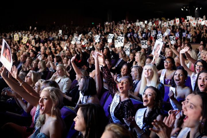 Audience members cheer contestants during the 2010 Miss America pageant.