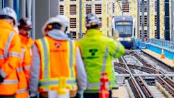 Sound Transit employees greet an approaching test train operator during a station tour in March 2024.