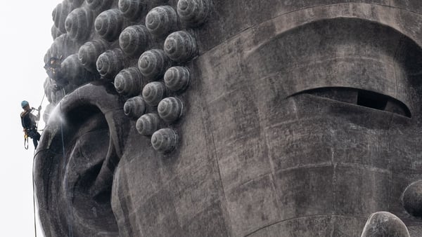 Cleaner Kazuyoshi Taguchi clean the right ear of the Ushiku Daibutsu giant Buddha statue in Ushiku of Ibaraki Prefecture