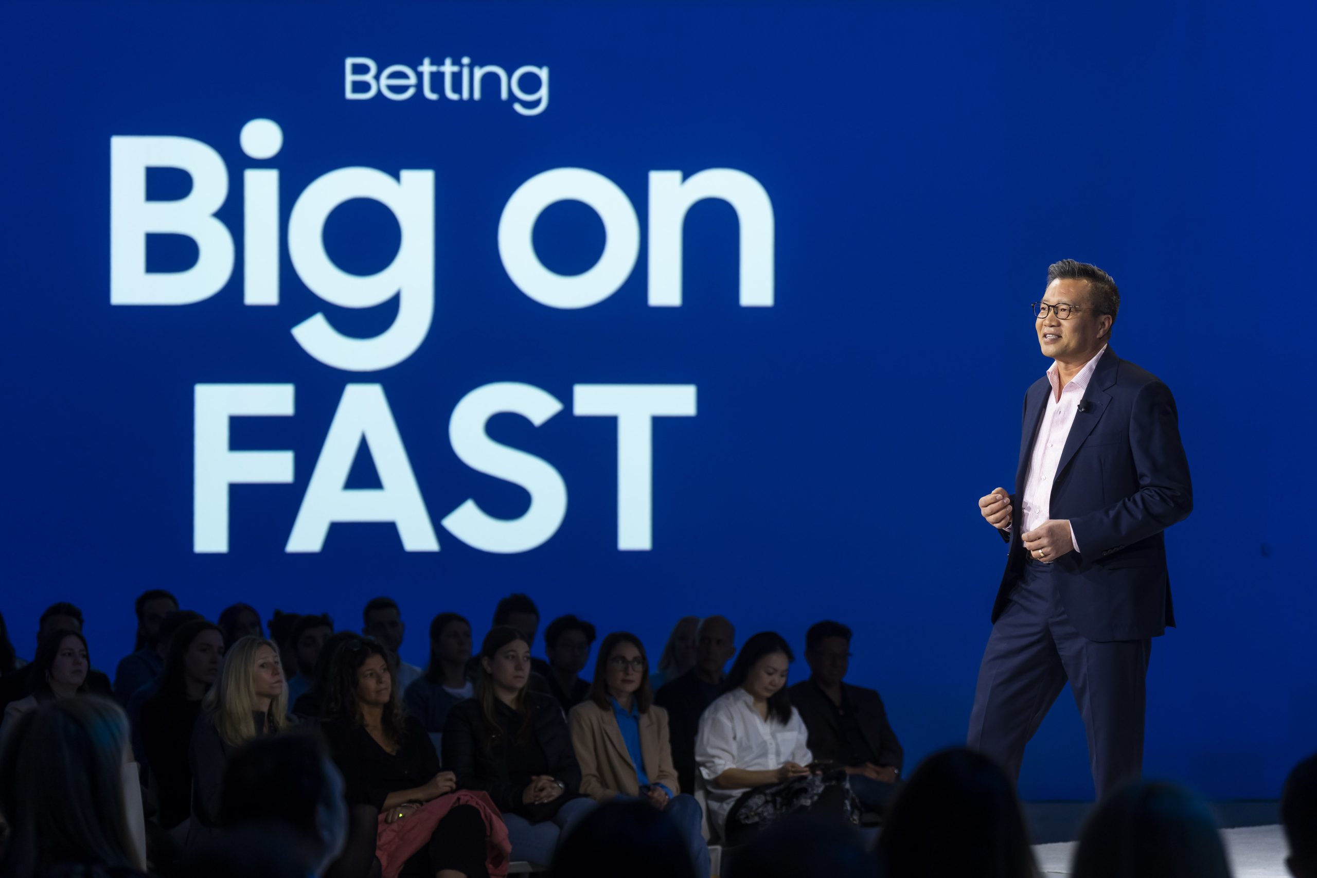 Speaker in front of a sign that states Betting Big on Fast
