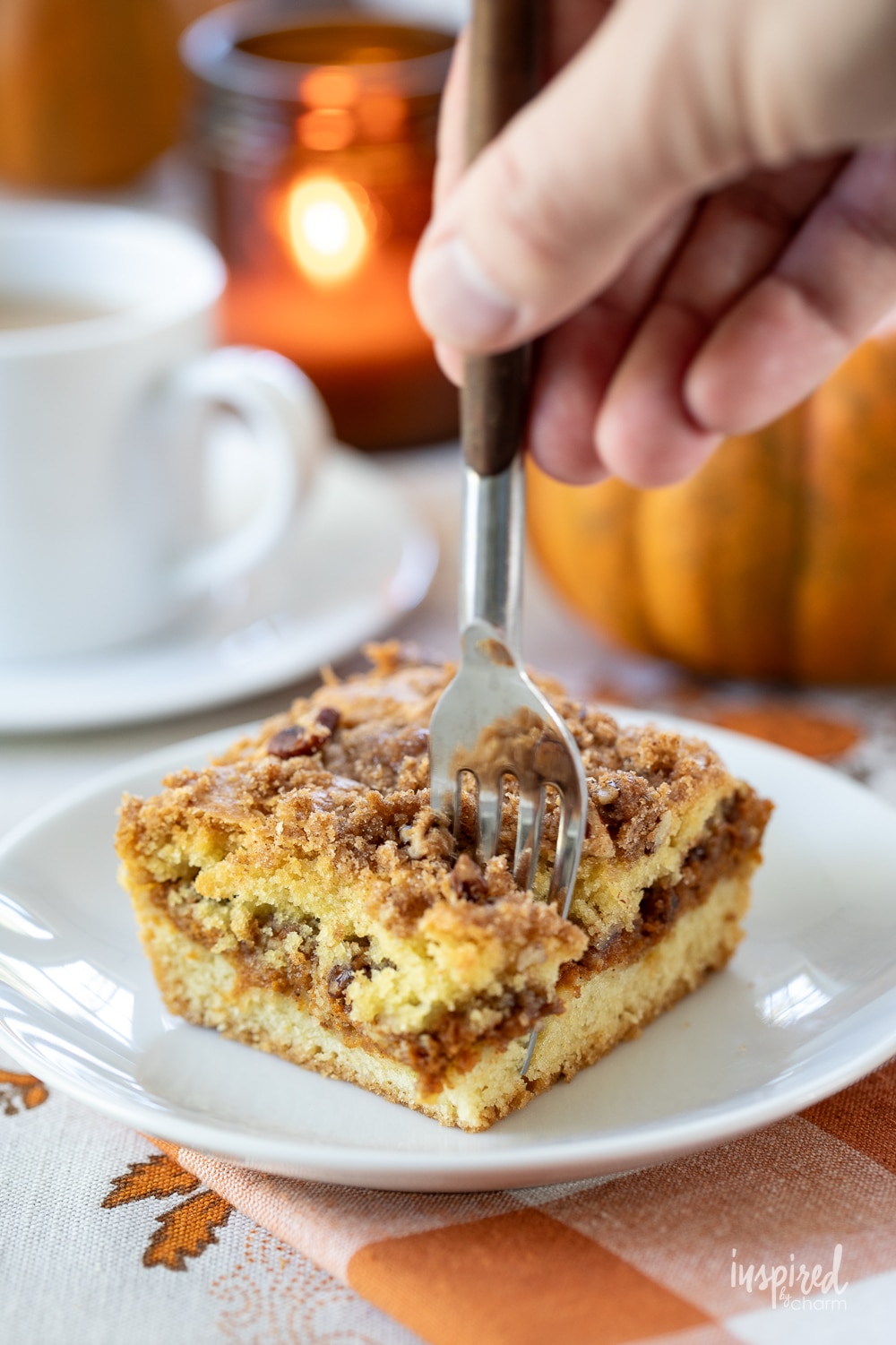 hand with fork taking a bite of pumpkin swirl coffee cake.