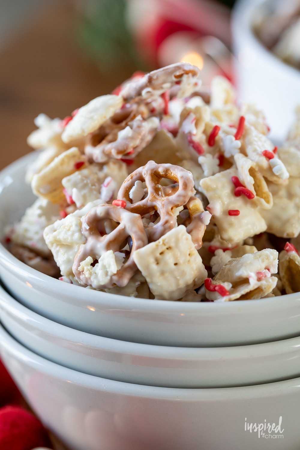 peppermint white chocolate chex mix in a stack of white bowls.