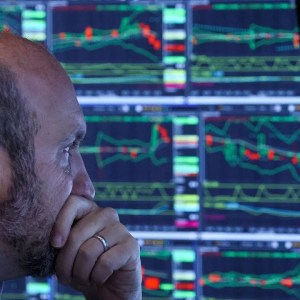 Foto de um homem olhando para cotações do Ibovespa. A matéria descreve como gestores deixaram de lado cenário em que Ibovespa bate 140 mil pontos em 2024.