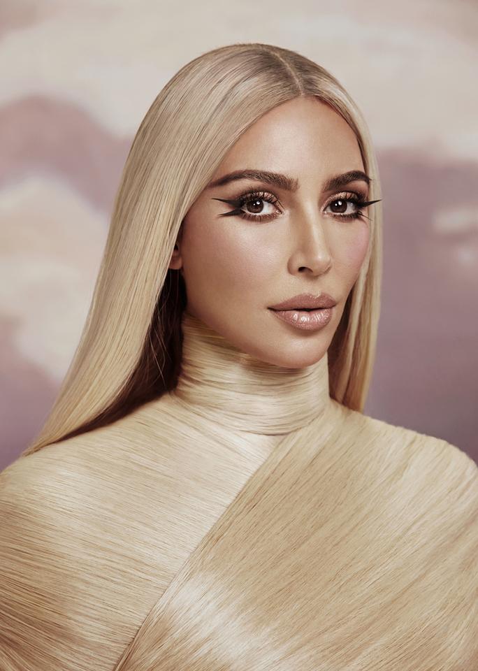Portrait of Kim Kardashian for Allure Magazine. She’s wrapped in hair the same blonde as the hair on her head and wears a dramatic winged smoky eye.