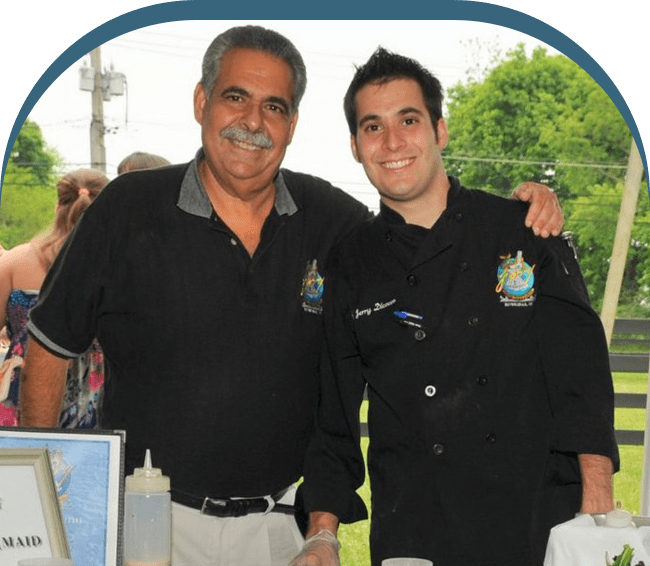 Two men standing next to each other at a table.