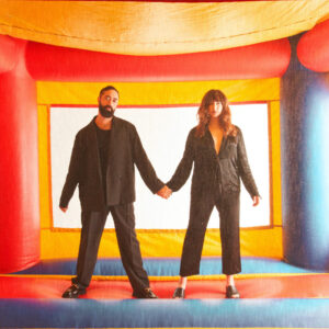 Duo of Brijean standing in a bounce house.