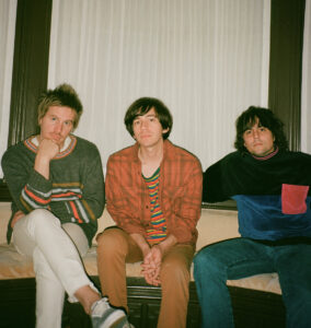 Three members of French Cassettes sitting in a room together.