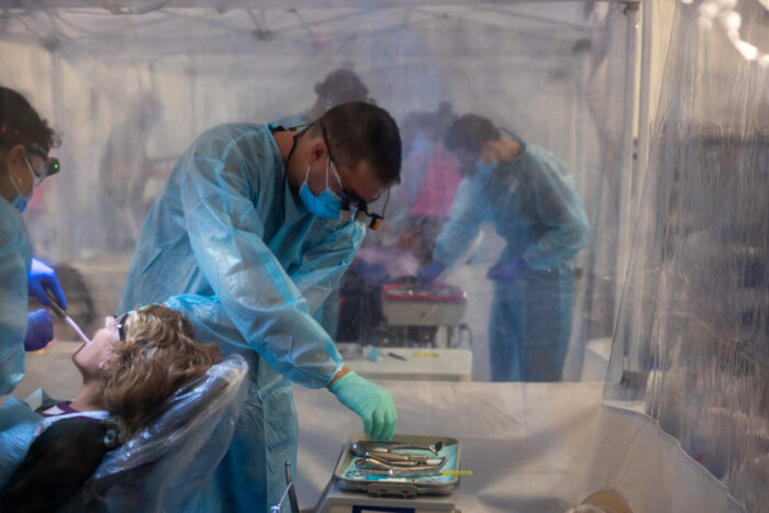 Dental students, working as volunteers, attend to patients at a Remote Area Medical mobile dental and medical clinic on Oct. 7, 2023 in Grundy, Virginia. More than 1,000 people were expected to seek free dental, medical and vision care at the two-day event. (Photo by Spencer Platt/Getty Images)