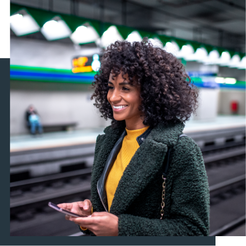 Women smiling on a phone in a train station