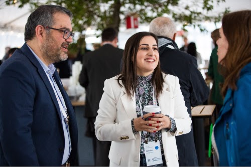 Tres personas conversando en un encuentro profesional.