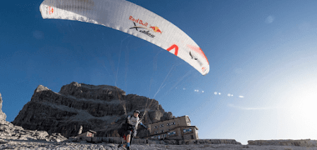 Person wearing a parachute on the beach