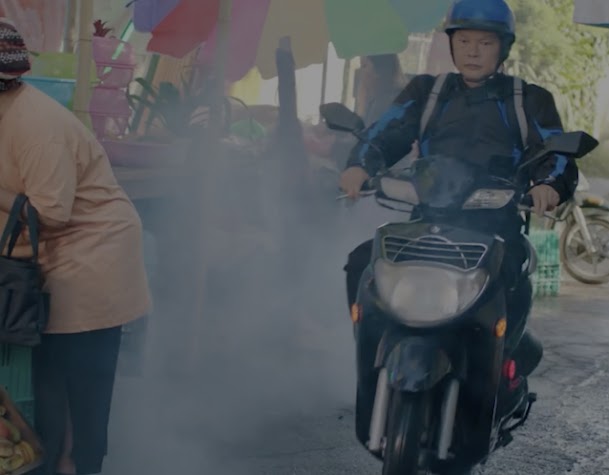 Delivery person on a motorbike riding through a market