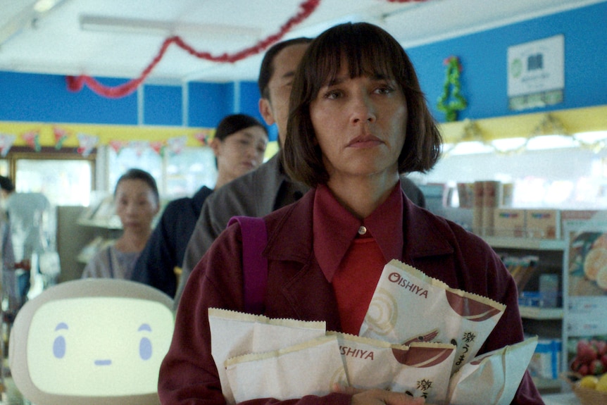 A woman stand in line at a grocery story in front of a white robot and other humans