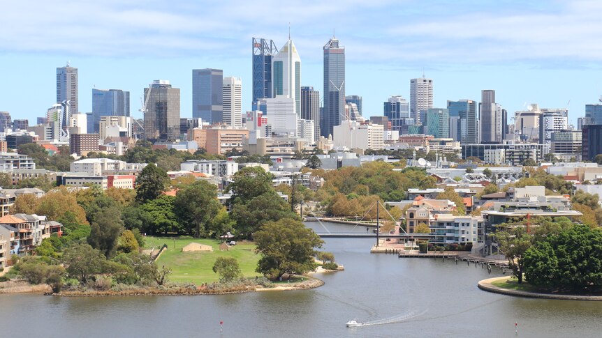 Towers of concrete, and steel in the background and a river system in the foreground.